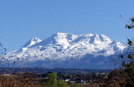 Iztaccíhuatl volcano covered with snow as seen from a distance Iztaccíhuatl volcano covered with snow as seen from a distance
